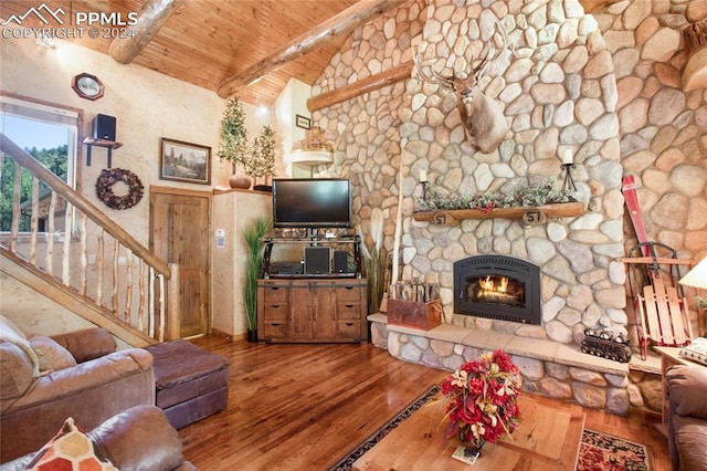 living room with vaulted ceiling with beams, a fireplace, wooden ceiling, and hardwood / wood-style flooring