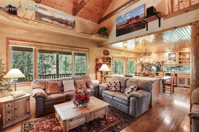 living room featuring wood ceiling, high vaulted ceiling, a chandelier, and a healthy amount of sunlight