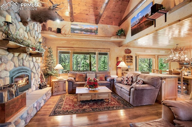 living room featuring hardwood / wood-style flooring, a stone fireplace, wooden ceiling, and plenty of natural light