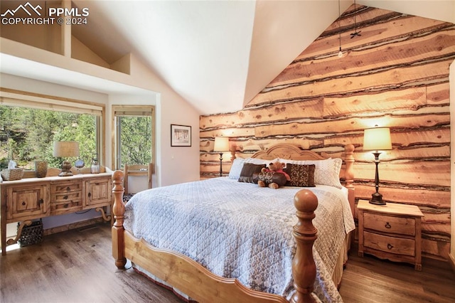 bedroom featuring dark hardwood / wood-style floors, log walls, and high vaulted ceiling