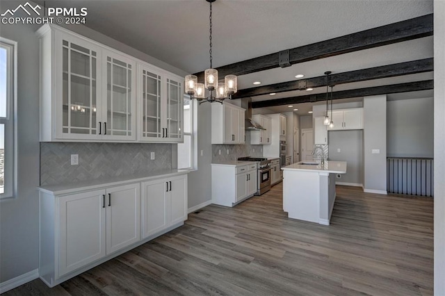 kitchen featuring high end stainless steel range, white cabinetry, wood-type flooring, a center island with sink, and wall chimney range hood