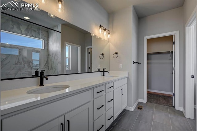 bathroom featuring vanity, tile patterned floors, and tiled shower