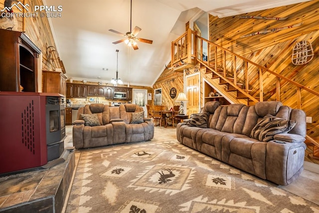 living room with ceiling fan, high vaulted ceiling, and wood walls