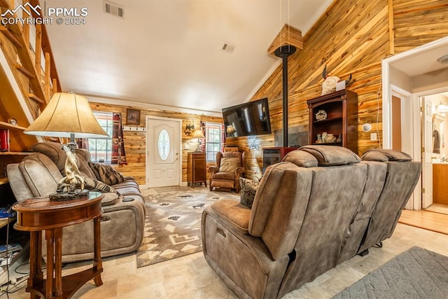 living room featuring a wealth of natural light, wooden walls, lofted ceiling, and light tile patterned floors