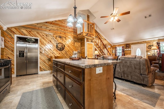 kitchen featuring light tile patterned flooring, stainless steel appliances, wood walls, and lofted ceiling