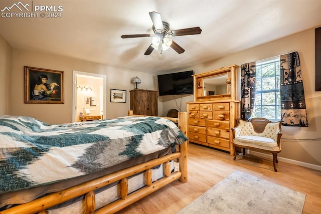 bedroom with ceiling fan, connected bathroom, and light hardwood / wood-style flooring