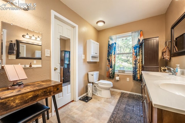 bathroom with toilet, dual bowl vanity, and tile patterned floors