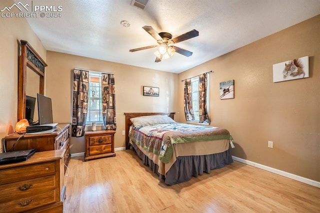 bedroom with multiple windows, light wood-type flooring, and ceiling fan