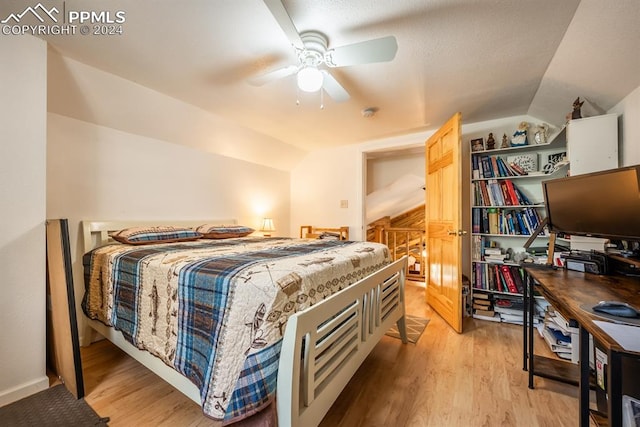 bedroom with ceiling fan, light hardwood / wood-style flooring, and lofted ceiling