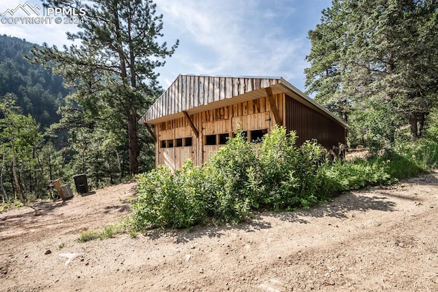 rear view of property featuring an outbuilding