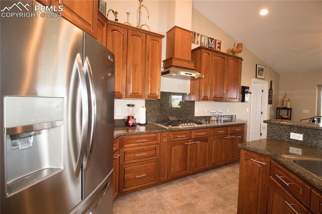 1933 Top Notch Trl, Penrose, CO 81240 - kitchen with lofted ceiling, stainless steel appliances, dark stone countertops, brown cabinets, and decorative backsplash