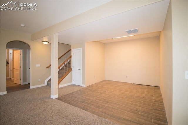 1933 Top Notch Trl, Penrose, CO 81240 - basement with wood finished floors, visible vents, baseboards, stairway, and arched walkways