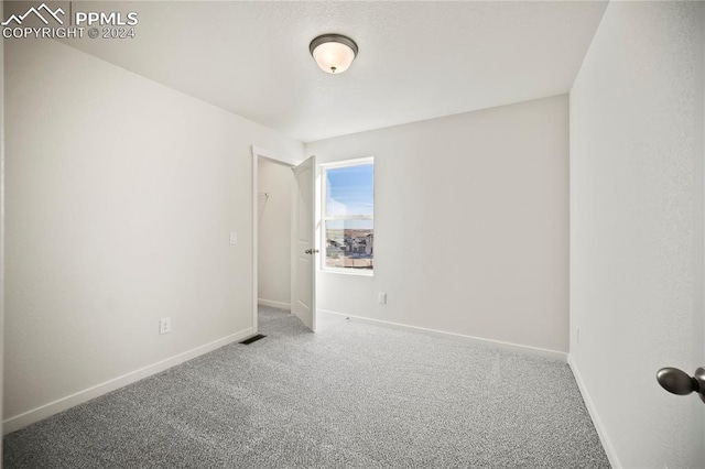 carpeted spare room with baseboards and visible vents