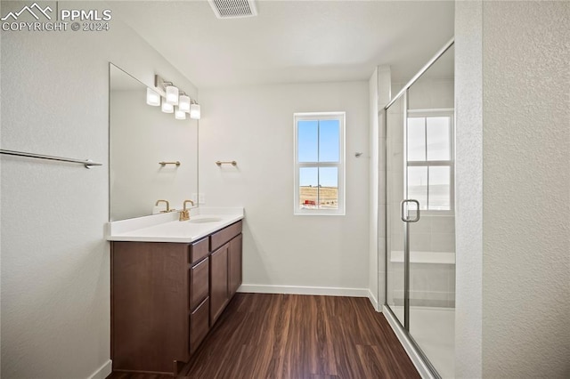 bathroom featuring hardwood / wood-style floors, vanity, and a shower with shower door