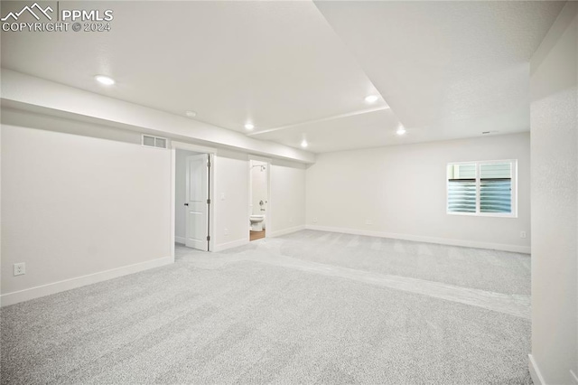 basement featuring light carpet