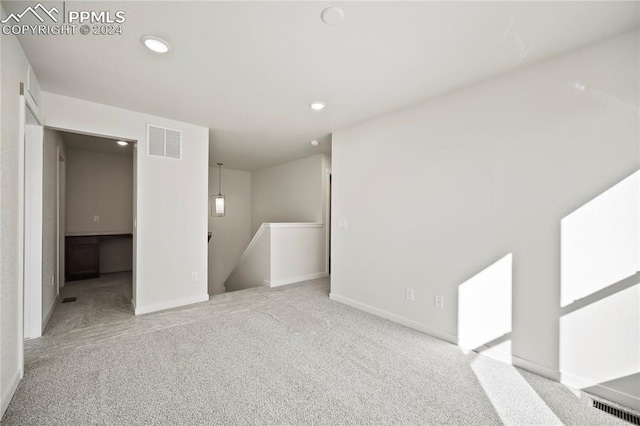 unfurnished living room featuring carpet, visible vents, baseboards, and recessed lighting