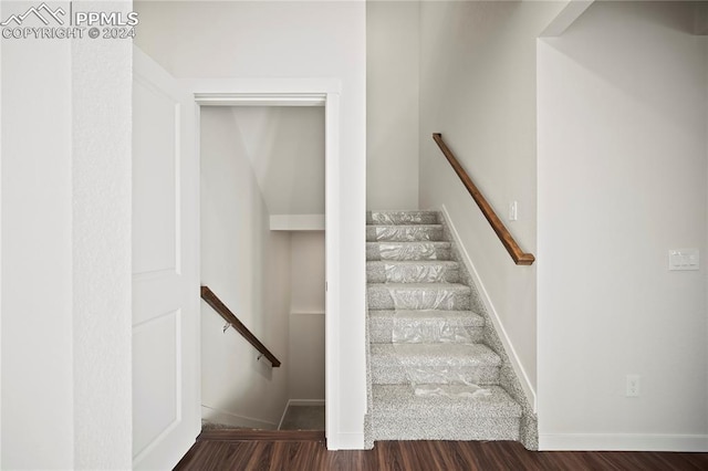 staircase featuring wood finished floors and baseboards