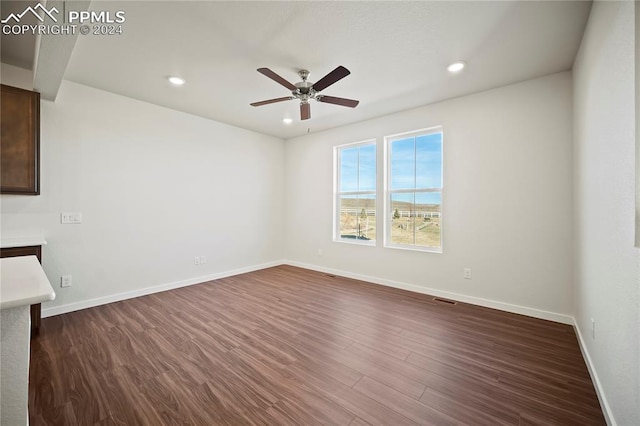 spare room featuring baseboards, visible vents, and dark wood-type flooring