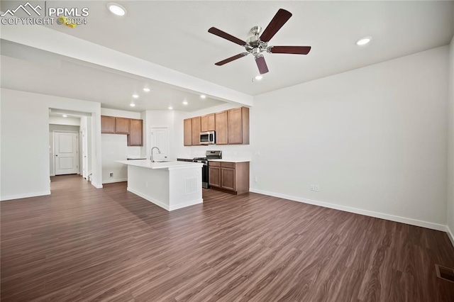 kitchen with dark wood-style flooring, appliances with stainless steel finishes, open floor plan, and a sink