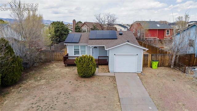 view of front facade with a garage and solar panels