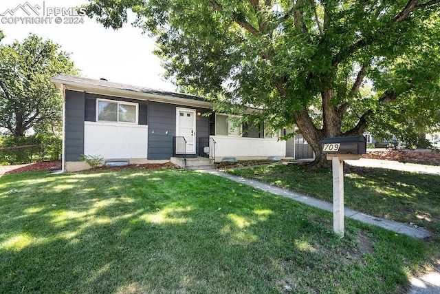 single story home featuring a front lawn