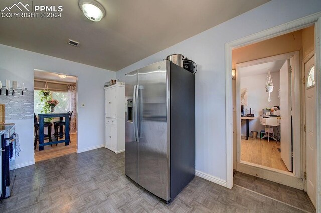 kitchen with backsplash, stainless steel fridge with ice dispenser, and hardwood / wood-style floors