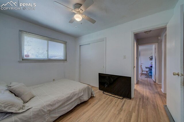 bedroom with ceiling fan, light hardwood / wood-style flooring, and a closet