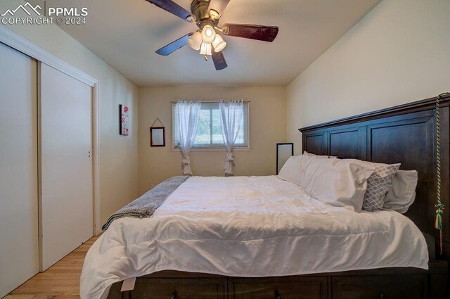 bedroom with ceiling fan, light hardwood / wood-style flooring, and a closet