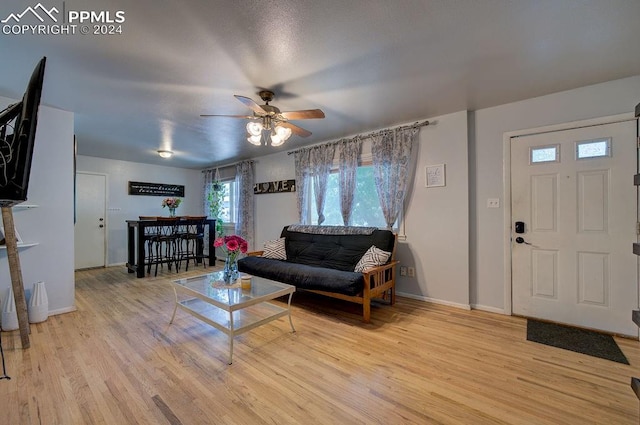 living room with light hardwood / wood-style floors and ceiling fan