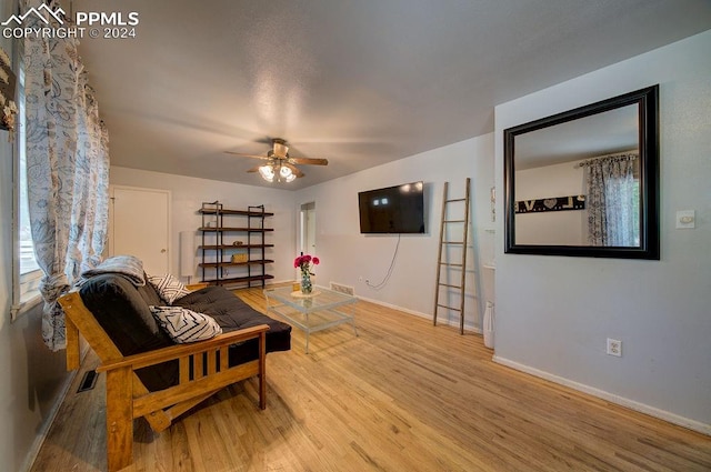 living room featuring ceiling fan and light hardwood / wood-style flooring