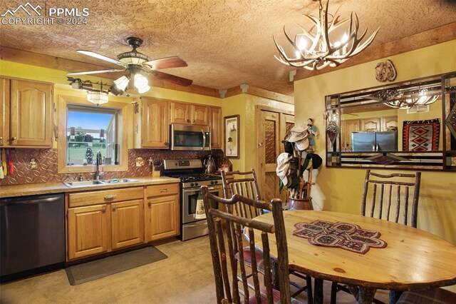 kitchen featuring sink, appliances with stainless steel finishes, tasteful backsplash, and decorative light fixtures