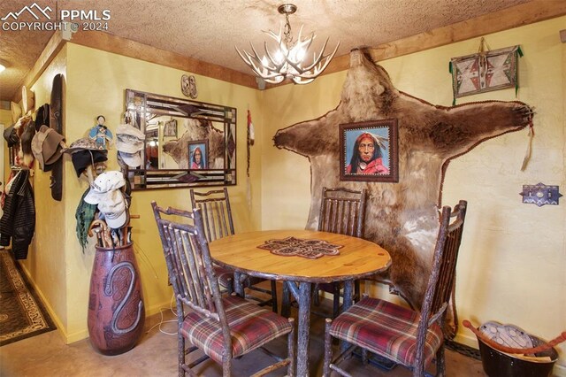 dining space with a textured ceiling and a notable chandelier