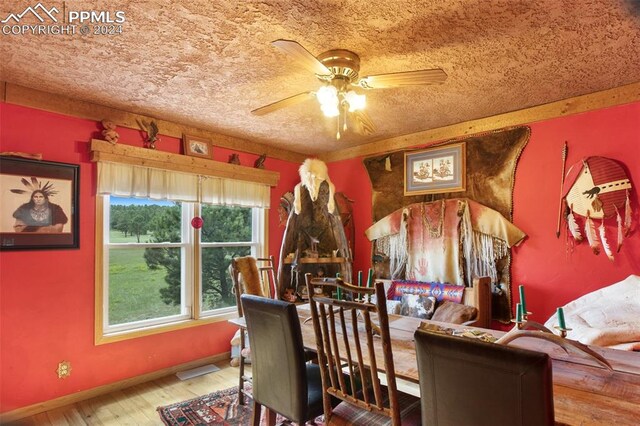 dining area with a textured ceiling, wood-type flooring, and ceiling fan