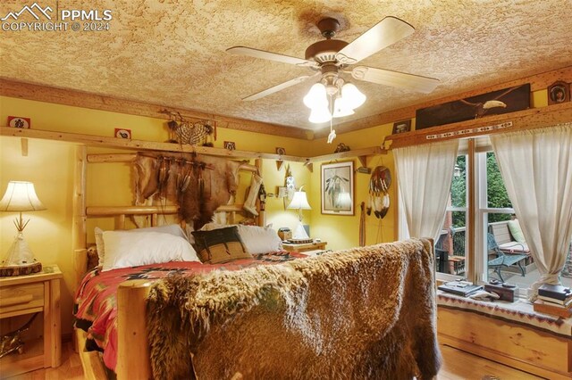 bedroom featuring hardwood / wood-style flooring, ceiling fan, a textured ceiling, and access to outside