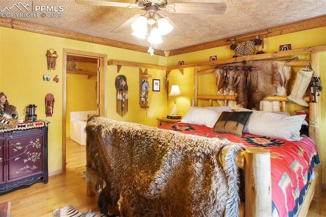 bedroom with ceiling fan, a spacious closet, a textured ceiling, and light wood-type flooring