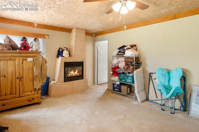 interior space with ceiling fan, light carpet, and a textured ceiling