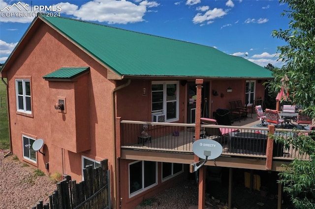 back of house featuring a wooden deck and a patio