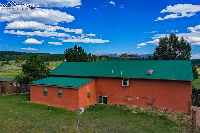 view of property exterior with a mountain view and a yard