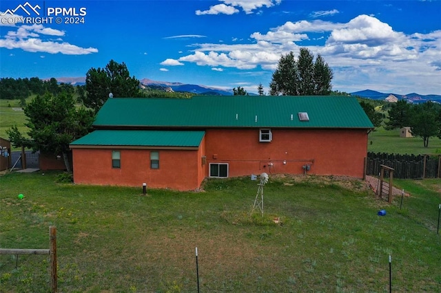 rear view of property with a yard and a mountain view