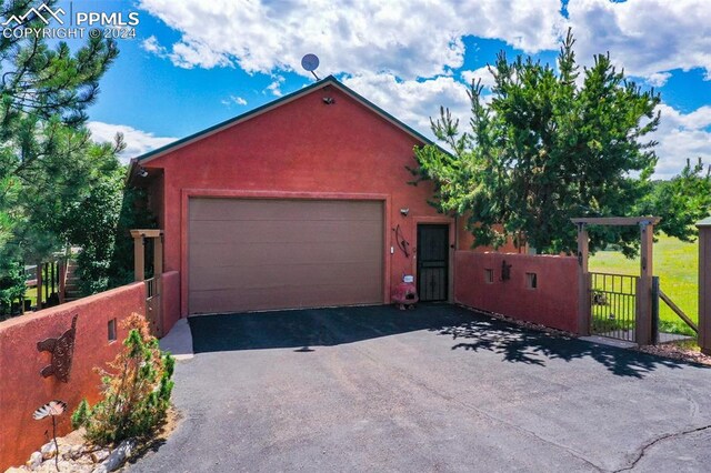 view of front of home featuring a garage and an outbuilding