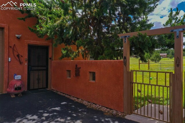 view of gate with a yard