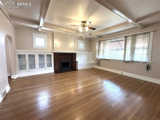 unfurnished living room featuring arched walkways, coffered ceiling, dark wood finished floors, and baseboards