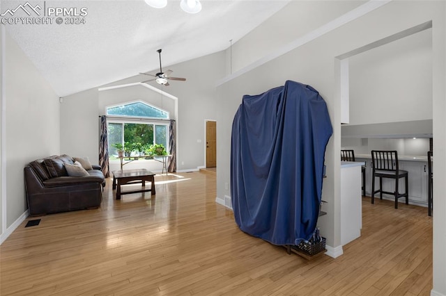 interior space featuring ceiling fan, high vaulted ceiling, and light hardwood / wood-style flooring