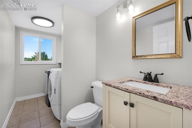 bathroom with tile patterned flooring, washing machine and clothes dryer, vanity, and toilet