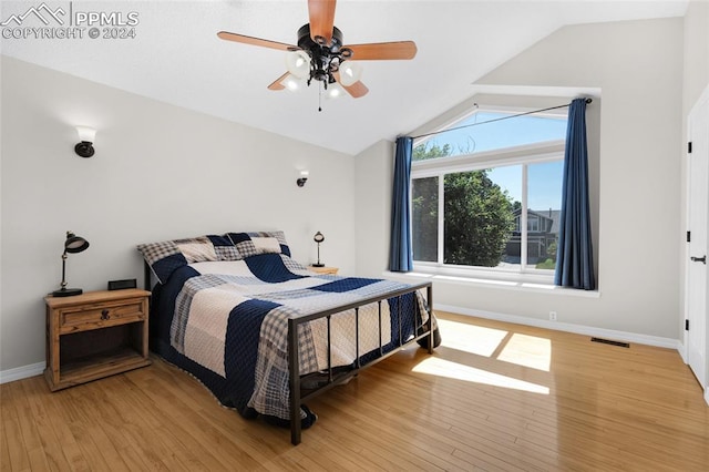 bedroom with light hardwood / wood-style floors, vaulted ceiling, and ceiling fan