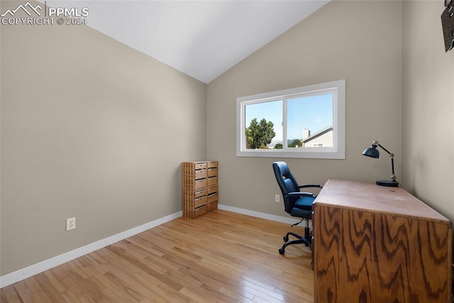 office space with light wood-type flooring and vaulted ceiling