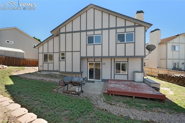 rear view of house featuring a wooden deck and a yard