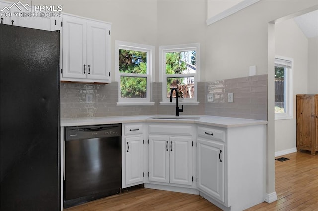 kitchen featuring light hardwood / wood-style floors, white cabinetry, sink, black appliances, and lofted ceiling