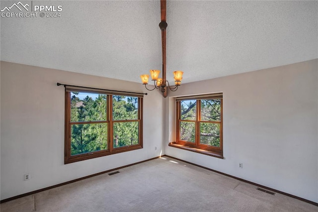 unfurnished room with lofted ceiling, a textured ceiling, carpet floors, and a chandelier