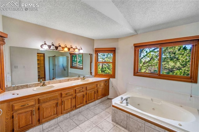 bathroom featuring vanity, separate shower and tub, tile patterned flooring, and a textured ceiling